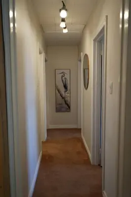a hallway with a painting of a bird on a branch at Mary Lake Sunset Lodge in Port Sydney