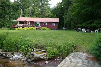 a red cabin in the middle of a yard at Mary Lake Sunset Lodge in Port Sydney