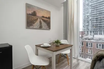 a dining room with a table and chairs and a window at 1BD next to Queen St - most ideal location in Toronto