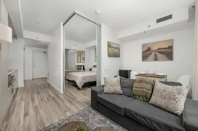 a living room with a couch and a bedroom at 1BD next to Queen St - most ideal location in Toronto