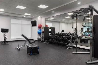 a room with a gym with weights and a tv at Home2 Suites By Hilton Woodstock On in Woodstock