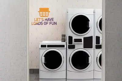three washing machines and a washer and dryer in a room at Home2 Suites By Hilton Woodstock On in Woodstock