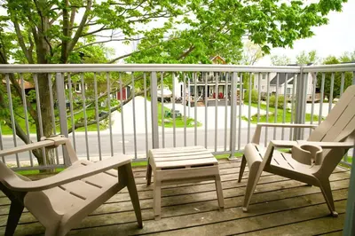 two chairs and a stool sitting on a porch at Cozy, 4 Bedroom Chalet, 10 min walk to Village in Blue Mountains