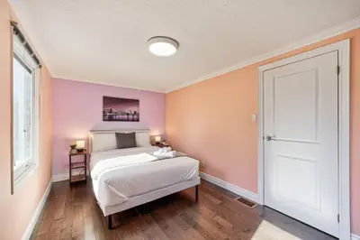 a bedroom with a white bed and pink walls at 4BR Scarborough Gem, Freshly Renovated, 7 Car Parking in Toronto