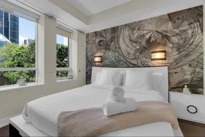 a bedroom with a bed with a doll sitting on it at 1560 sqft Elegant Condo at Downtown Hi-End Shopping & Dining Area - CN Tower View, Bidet, LockBox in Toronto