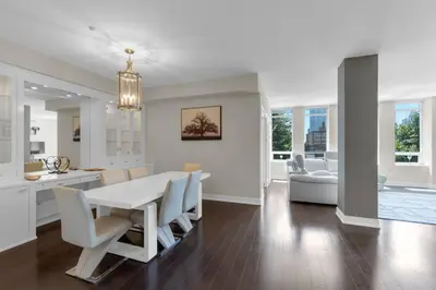 a kitchen and dining room with a white table and chairs at 1560 sqft Elegant Condo at Downtown Hi-End Shopping & Dining Area - CN Tower View, Bidet, LockBox in Toronto