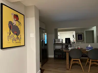 a living room with a table and a painting of a chicken at Luxurious Private Apartment in Oakville