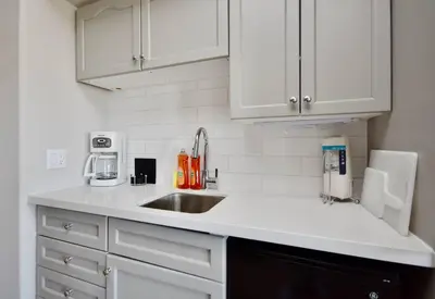 a kitchen with white cabinets and a sink at Relaxing Top Level Studio in Edgar