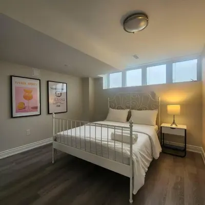 a bedroom with a large bed and a window at Cozy Hideaway in Thorold