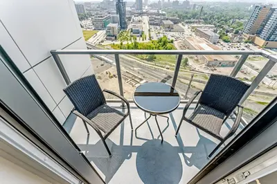 a balcony with two chairs and a table on a building at Newly Built Condo with Amazing Views in Kitchener