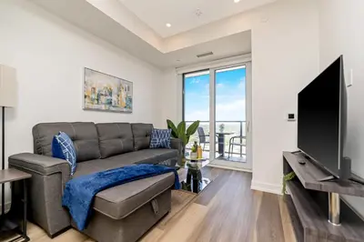 a living room with a couch and a flat screen tv at Modern High Rise King bed Condo with Private Balcony in Kitchener