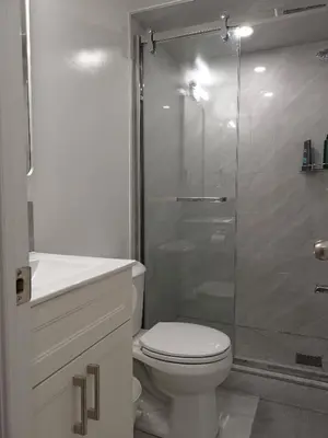 a bathroom with a toilet and a glass shower at Cozy Private Rooms in Basement in Richmond Hill