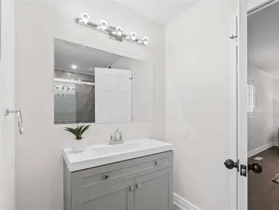a white bathroom with a sink and a mirror at Beautiful 3 bedroom Entire detached home in Whitby