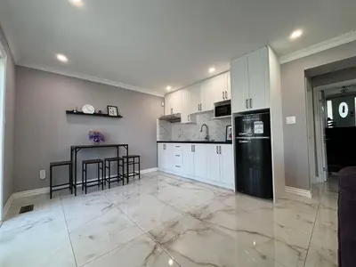 a kitchen with white cabinets and a black refrigerator at Willowdale in Toronto