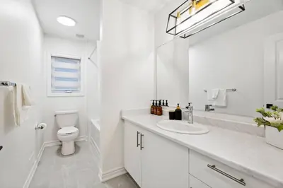 a white bathroom with a sink and a toilet at Luxury Vacation Home Near Lake Pool Table in Barrie
