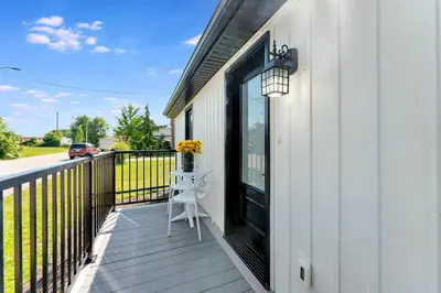 a porch with a table and a chair on a balcony at Luxe Lodges Lake Erie in Port Dover