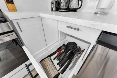 an open drawer in a white kitchen with utensils at RentX 3Bed Cozy Home - Hospital GO 2ParkingWi-Fi in Hamilton