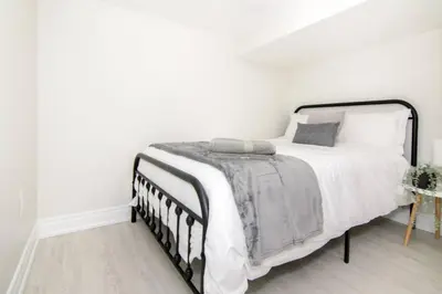 a white bedroom with a black and white bed at RentX Modern Suite - Near GO Hospital Parking in Hamilton