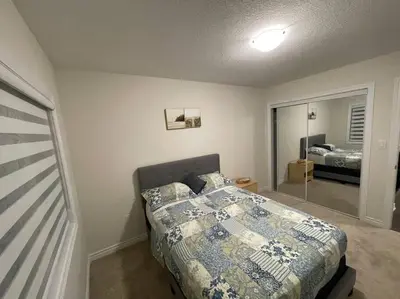 a bedroom with a bed and a bedroom with a mirror at Cozy 3-Bedrooms T-Home #Niagara in Thorold