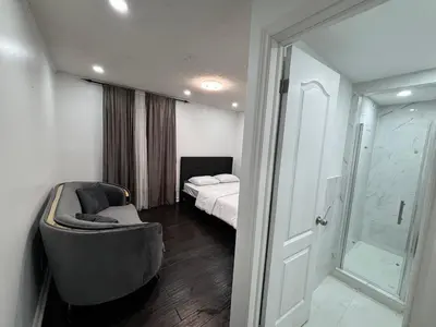 a bedroom with a bed and a chair and a shower at Entire bungalow, full privacy, free parking in Oshawa
