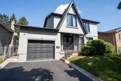 a white house with a garage at Chic and Cozy 5 Bedroom House in Brampton