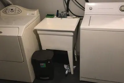 a small kitchen with a sink and a washing machine at Affordable 2BR Family Friendly Basement Apt in Bowmanville