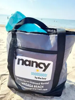 a bag sitting on the sand at the beach at Nancy by the Bay Wasaga Beach in Wasaga Beach