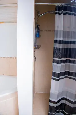 a shower with a black and white shower curtain in a bathroom at Cozy Haven 2 bedroom Basement apartment with Treated water in London