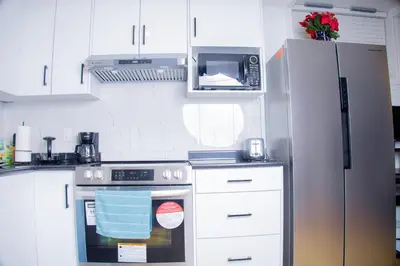 a kitchen with a stove and a refrigerator at Cozy Haven 2 bedroom Basement apartment with Treated water in London