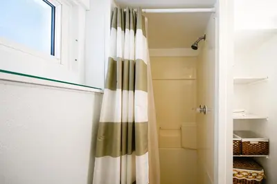 a bathroom with a shower curtain in a closet at Charming Basement Suite with Private Entrance Near Subway, Koreatown & UofT in Toronto