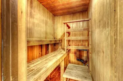 a wooden sauna with wooden shelves and a bench in it at 6 bdrm Cottage at Blue Mountain, Private Beach Access, Hot Tub, Sauna, BBQ, Petfriendly in Blue Mountains