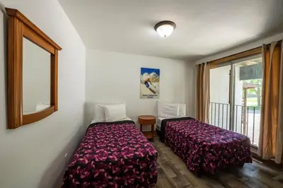 a bedroom with two beds and a window at 6 bdrm Cottage at Blue Mountain, Private Beach Access, Hot Tub, Sauna, BBQ, Petfriendly in Blue Mountains