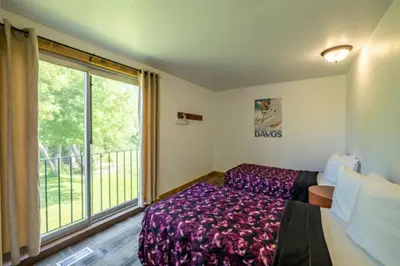 a bedroom with a bed and a large window at 6 bdrm Cottage at Blue Mountain, Private Beach Access, Hot Tub, Sauna, BBQ, Petfriendly in Blue Mountains