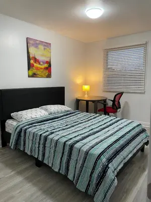 a bedroom with a bed and a table in it at Toronto Midtown Room with Queen Bed in Toronto