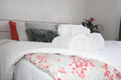 a bed with white towels on top of it at Serene Don River Nature gateway- 2BR suite, Private Patio, Free Parking in Toronto
