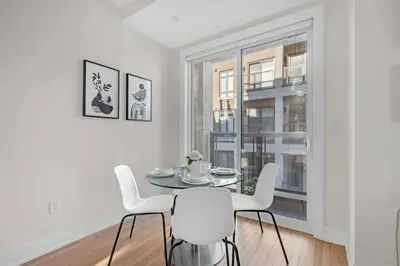 a dining room with a table and chairs and a window at Designer Yorkdale 2BR Townhouse, Private Patio, Parking in Toronto