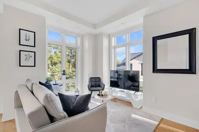 a living room with a couch and a tv at Designer Yorkdale 2BR Townhouse, Private Patio, Parking in Toronto