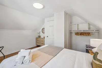 a white bedroom with a bed with towels on it at Heritage 3BR Etobicoke Gem, Sherway Gardens, BBQ in Toronto
