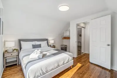 a white bedroom with a bed with two towels on it at Heritage 3BR Etobicoke Gem, Sherway Gardens, BBQ in Toronto