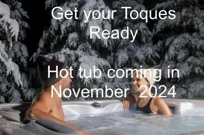 a woman in a hot tub in a snow covered bathtub at Gate House Comfort plus own lake access, dock, 4 mins to beach in West Lake