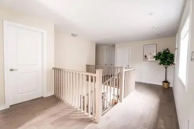 a white room with a staircase with a potted plant at Spotless 4 bed and 3 bath with Wi-Fi and 1hr to Niagara in Hamilton
