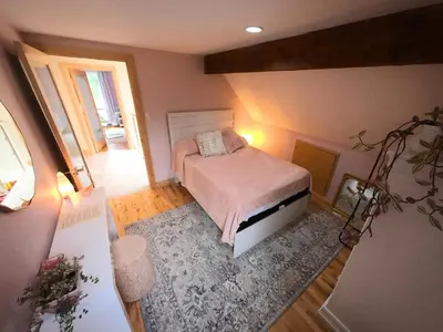 a small bedroom with a bed and a rug at Riverside Retreat with Sauna & Hot Tub in Elora in Elora