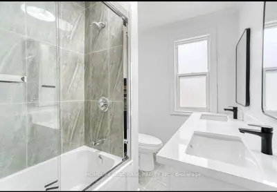 a bathroom with a shower and a sink and a toilet at H men's dormitory in Hamilton