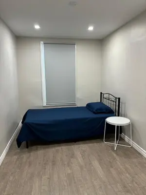 a bedroom with a blue bed and a table at H men's dormitory in Hamilton