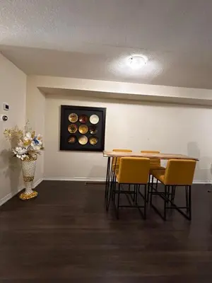 a room with a table with chairs and a painting of donuts at Mimis lodge in Brampton