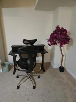 a black desk with a chair and a plant with purple flowers at Mimis lodge in Brampton