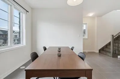 a conference room with a wooden table and chairs at A Brand New 4BR Townhouse in Thorold Retreat in Thorold