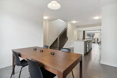 a dining room with a wooden table and chairs at A Brand New 4BR Townhouse in Thorold Retreat in Thorold