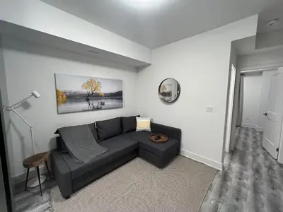 a living room with a black couch and a table at 2 Bed Town ideal for a fun-filled family vacation in Niagara Falls