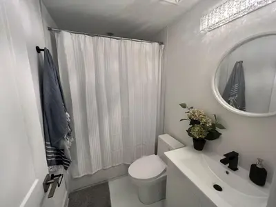 a bathroom with a toilet and a sink and a mirror at 2 Bed Town ideal for a fun-filled family vacation in Niagara Falls